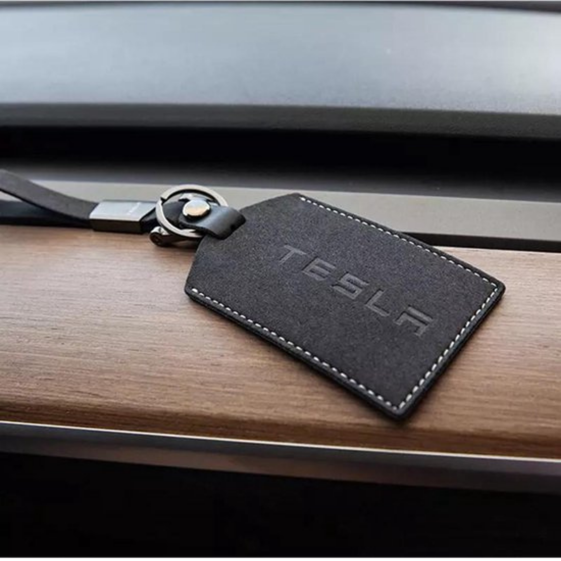 Hand hält eine TESLA Schlüsselkarte vor ein Model Y. Schlüsselkarte zum  aufsperren und zusperren eines Elektro Fahrzeuges der Marke Tesla -  CHROMORANGE