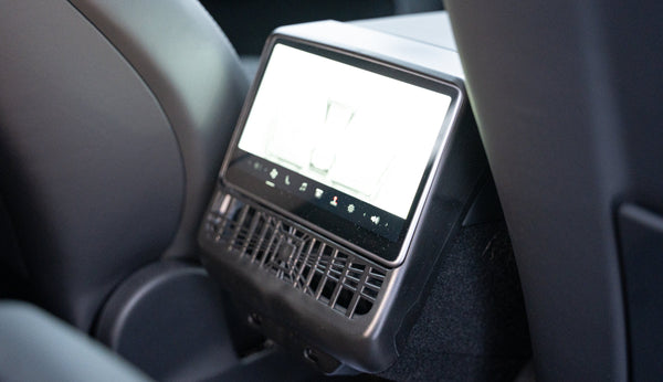 Displayschutzrahmen am hinteren Display des Tesla Model Y Juniper Premium montiert, zwischen den Vordersitzen.
