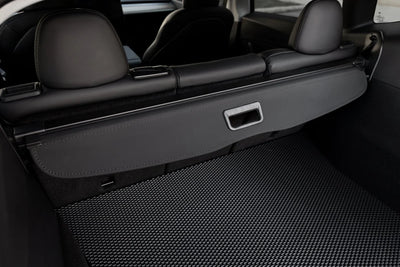 Innenansicht der eingerollten Kofferraumabdeckung Model Y Juniper 2025+, perfekt abgestimmt auf das Tesla Interieur in Schwarz.