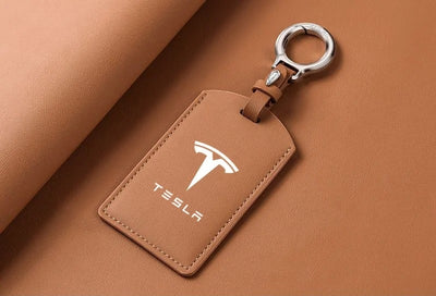 Brauner Tesla Schlüsselanhänger mit weißem T-Logo, Schlüsselkarte Hülle und praktischem Schlüsselring für stilbewusste Tesla-Fahrer.