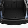Offener, leerer Kofferraum mit Spigen Ladekantenschutz für Tesla Model Y als dunklem Streifen auf der hinteren Stoßstange.
