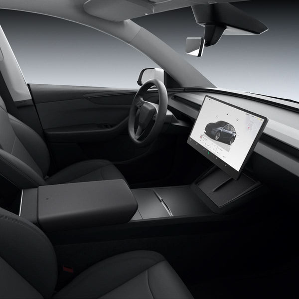 Tesla-Innenraum mit schwarzer Spigen-Schutzauflage unter dem Bildschirm, von der Beifahrerseite mit Lenkrad und Mittelkonsole gesehen.