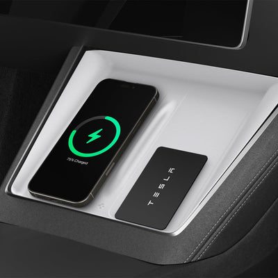 Weiße Spigen-Schutzauflage in der Mittelkonsole, links ein Smartphone mit grünem Ladesymbol und rechts eine schwarze Tesla-Karte.