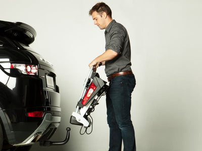 Zusammengefalteter Yakima FoldClick 2 EVO Fahrradträger im Kofferraum eines Tesla Model Y – kompakt, leicht und platzsparend verstaubar.
