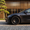 Tesla Model 3 Performance Felgen 19 Zoll The New Aero Razor V2, Detailaufnahme Vorderrad vor moderner Architektur.