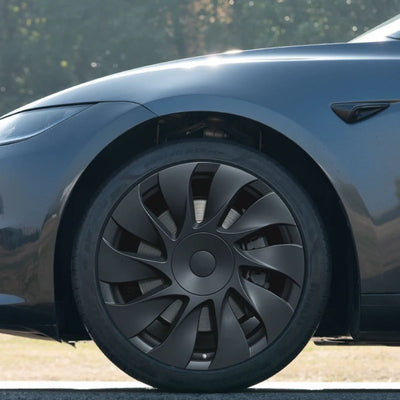 Nahaufnahme der Tesla Model 3 Radkappen 18 Zoll Highland Standard RWD im Uberturbine-Design, montiert auf einer originalen Prismata-Stahlfelge.