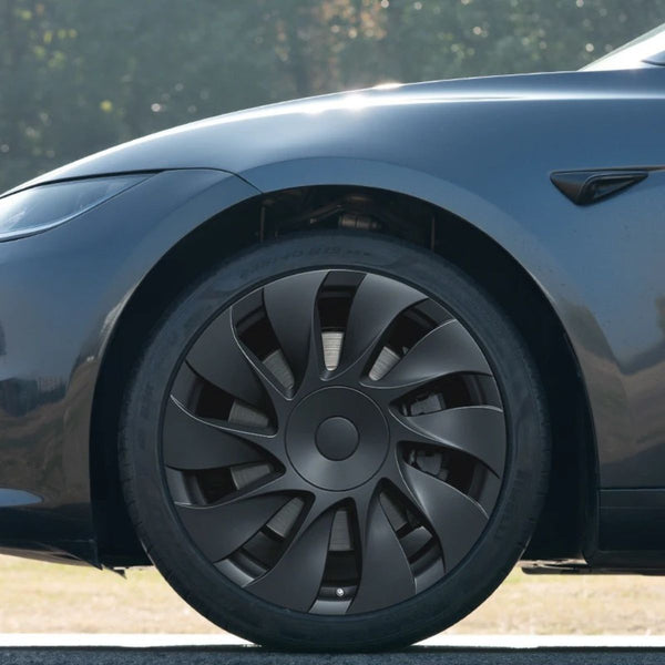 Nahaufnahme der Tesla Model 3 Radkappen 18 Zoll Highland Standard RWD im Uberturbine-Design, montiert auf einer originalen Prismata-Stahlfelge.