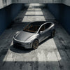 Graues Tesla Model Y Juniper mit CHELA Felgen in Matte Bronze und Satin Carbon, von oben in moderner Umgebung fotografiert.