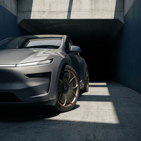 Graues Tesla Model Y Juniper, Nahaufnahme der vorderen CHELA Felge in Matte Bronze mit Satin-Carbon-Aerodisc.
