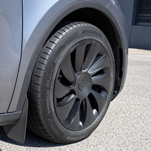Tesla Model Y Juniper Radkappen 19 Zoll Uberturbine schräg an einem grauen Model Y, mit Reifen, Radkasten und Schmutzfänger
