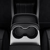 Draufsicht der Tesla Model Y Mittelkonsolen-Erweiterung mit leerem, geripptem Ablagefach und gebogenem Rand neben zwei Getränkehaltern.