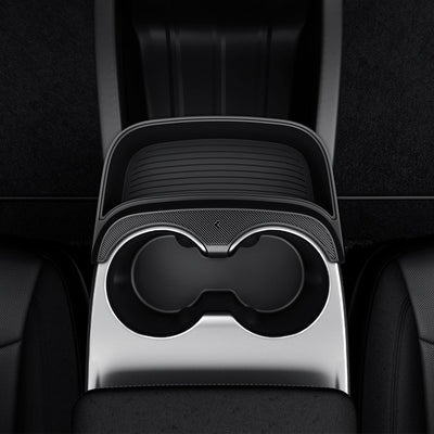 Draufsicht der Tesla Model Y Mittelkonsolen-Erweiterung mit leerem, geripptem Ablagefach und gebogenem Rand neben zwei Getränkehaltern.