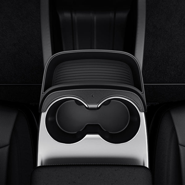 Draufsicht der Tesla Model Y Mittelkonsolen-Erweiterung mit leerem, geripptem Ablagefach und gebogenem Rand neben zwei Getränkehaltern.