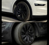 Tesla Model Y Juniper 2025+ mit montierten Radkappen Helix 20 Zoll in Schwarz – elegante Optik für weiße und schwarze Fahrzeugvarianten.