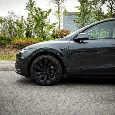 Seitenansicht eines Tesla Model Y Juniper mit montierten Radkappen schwarz 20 Zoll – stilvoll, aerodynamisch und passend für jede Farbe.