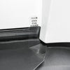 Detail des Tesla Stoßstangenschutzes an einer weißen Karosserie, mit transparenter Ausrichtlasche neben einer Leuchte.