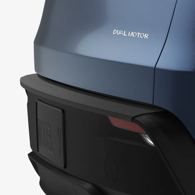 Tesla Stoßstangenschutz an der Ecke einer blauen Heckstoßstange, mit Dual Motor-Schriftzug über dem schwarzen Streifen.