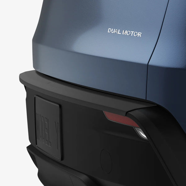 Tesla Stoßstangenschutz an der Ecke einer blauen Heckstoßstange, mit Dual Motor-Schriftzug über dem schwarzen Streifen.