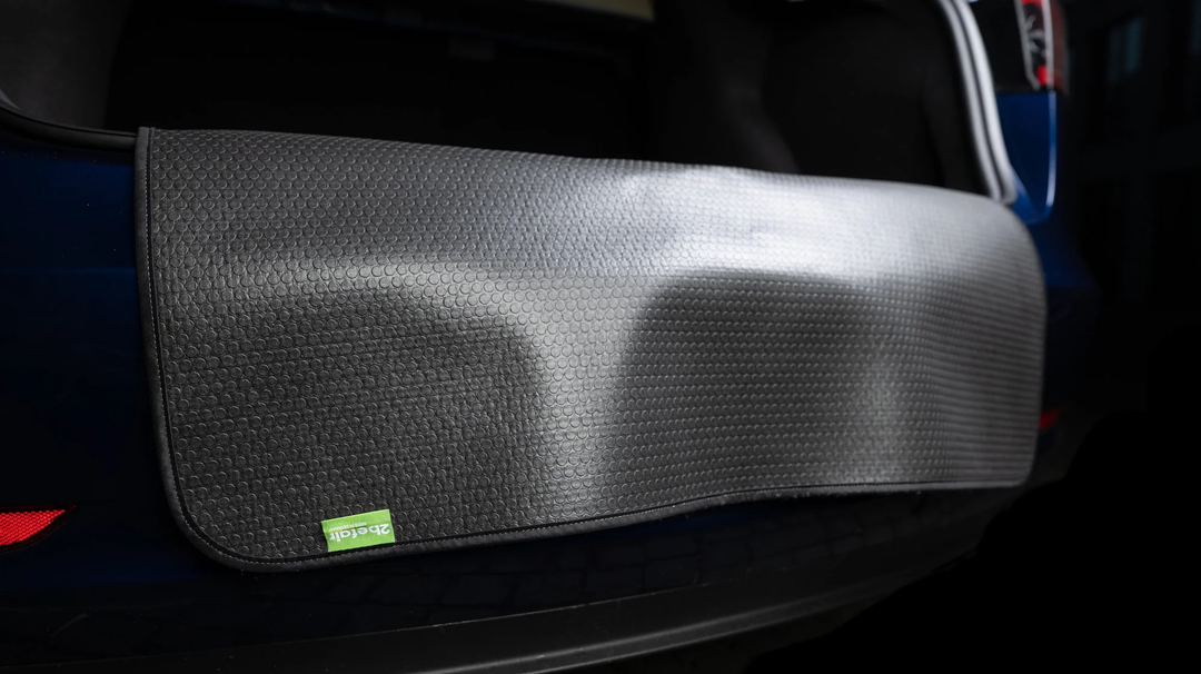 Schwarze 2befair Ladeklappenschutzmatte auf dem Kofferraumboden eines Tesla, schützt vor Kratzern und Dellen, nachhaltig produziert in Deutschland.